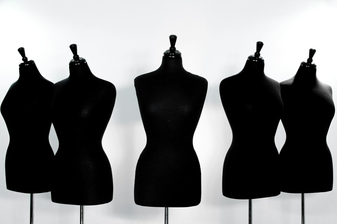A white background with 5 headless mannequins in black fabric